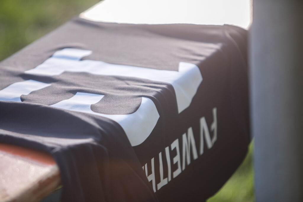 Schwarzes FW WETT Shirt auf Bank Outdoor.